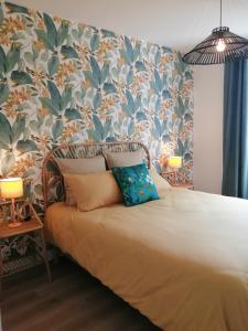 een slaapkamer met een bed met bloemenbehang bij Appartement aux Portes de St Goustan in Auray