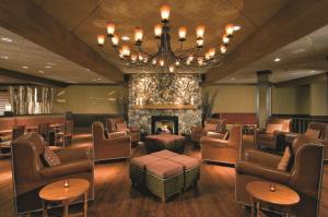 a waiting room with chairs and a fireplace at DoubleTree by Hilton Chicago - Arlington Heights in Arlington Heights +1 photo