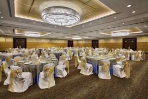um grande salão de banquetes com mesas e lençóis brancos. em DoubleTree by Hilton Chicago - Arlington Heights em Arlington Heights
