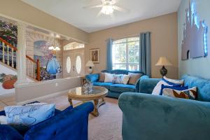 a living room with blue couches and a table at Happy Planet II in Davenport