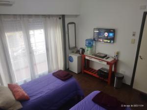 a bedroom with a bed and a tv and a table at Buenos Aires, CABA in Buenos Aires