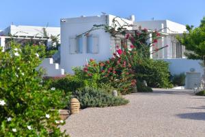 a garden in front of a white building with flowers at Portes Houses in Koufonisia