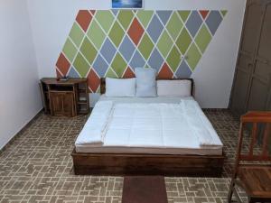 1 dormitorio con cama y mesa pequeña en Hotel Bella Vida, en Lomé