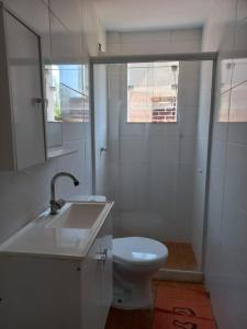 Baño blanco con lavabo y aseo en Suíte privativa na Barra da Tijuca proxima à praia, en Río de Janeiro
