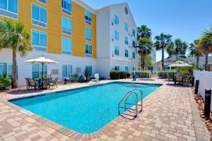 einem Pool vor einem Gebäude mit Palmen in der Unterkunft Hilton Garden Inn Jacksonville Orange Park in Orange Park