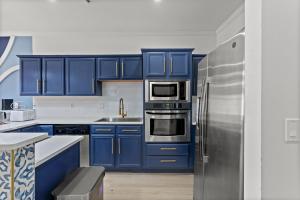 a kitchen with blue cabinets and a stainless steel refrigerator at Luxurious Home with Theatre Room in Myrtle Beach
