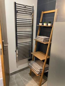 Cette chambre comprend un porte-serviettes et une étagère avec des serviettes. dans l'établissement Maison mitoyenne / hyper centre, à Lacroix-Saint-Ouen