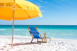 a beach chair and an umbrella on the beach at Hilton Sandestin Beach Golf Resort & Spa in Destin