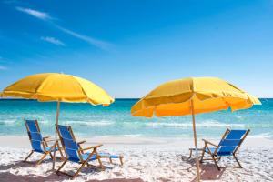 two chairs and two umbrellas on a beach at Hilton Sandestin Beach Golf Resort & Spa in Destin