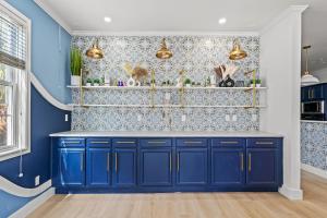 a kitchen with blue cabinets and a blue wall at Luxurious Home with Theatre Room in Myrtle Beach