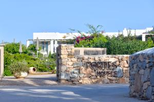 a stone wall with a house sign on it at Portes Houses in Koufonisia