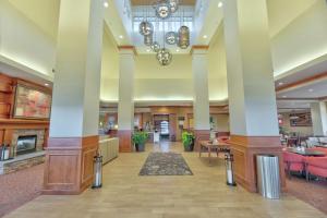 un hall d'un hôtel avec colonnes et tables dans l'établissement Hilton Garden Inn Laramie, à Laramie