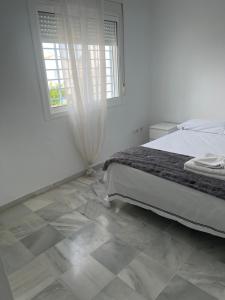 a bedroom with a bed and a tiled floor at Casa con piscina privada in El Puerto de Santa María