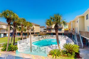 einen Pool mit Palmen vor den Eigentumswohnungen in der Unterkunft Sand Dollar #14 in Gulf Shores