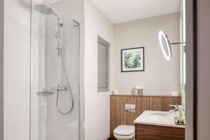 a bathroom with a shower and a toilet and a sink at DoubleTree by Hilton London Chelsea in London