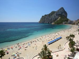 a beach with a lot of people and the ocean at AR Roca Esmeralda & SPA Hotel in Calpe