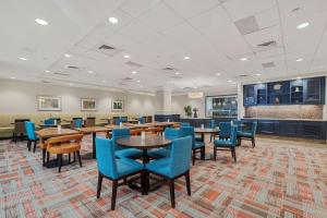 Hilton Garden Inn New Orleans French Quarter/CBD في نيو أورلينز: غرفة طعام مع طاولات وكراسي زرقاء