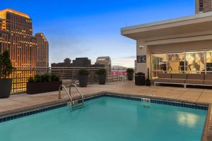 a swimming pool on top of a building with a city skyline at Hilton Garden Inn New Orleans French Quarter/CBD in New Orleans
