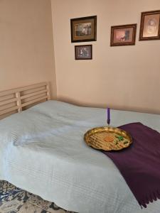Una cama con un tazón encima. en Allegro apartaments, en Šiauliai