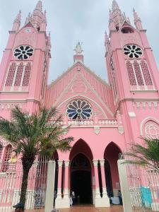 een roze kerk met een palmboom ervoor bij Aloja-T en Apartaloft amoblado en Jericó in Jericó