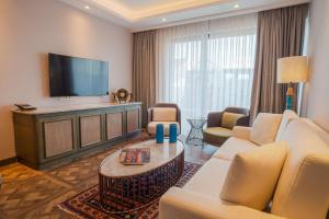 a living room with a couch and a tv at Burdock Hotel Istanbul, Autograph Collection in Istanbul