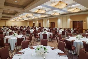 サンアントニオにあるDoubleTree by Hilton San Antonio Airportのテーブルと椅子が備わる広い宴会場 +26枚の写真