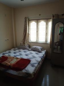 1 dormitorio con 1 cama grande y ventana en Bangalore homestay, en Bangalore