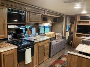 an rv kitchen with a stove and a couch at Penn State Weekender in State College