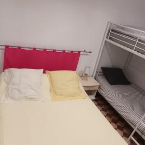 1 cama con 2 almohadas junto a una litera en La petite maison Lavandin 