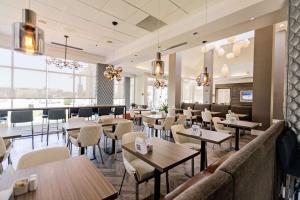 a restaurant with tables and chairs and a couch at Hilton Garden Inn Temple Medical Center in Temple