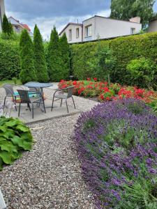 um jardim com mesa, cadeiras e flores em Happyfugu Domki Letniskowe em Międzyzdroje
