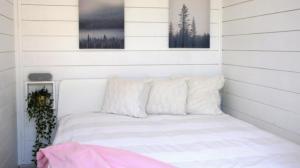 - une chambre avec un lit blanc et 2 oreillers dans l'établissement Happyfugu Domki Letniskowe, à Międzyzdroje