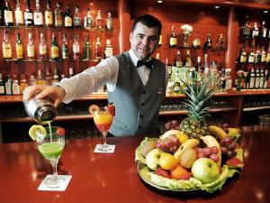 a man pouring a drink at a bar at AR Roca Esmeralda & SPA Hotel in Calpe
