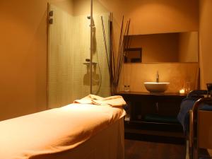 a bathroom with a bed and a sink and a shower at AR Roca Esmeralda & SPA Hotel in Calpe