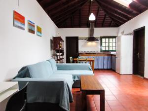 een woonkamer met een blauwe bank en een tafel bij La Bodega casa rural con piscina y jardines in Breña Baja