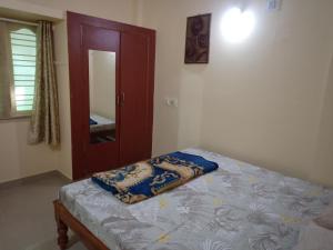 1 dormitorio con cama, espejo y puerta en Bangalore homestay, en Bangalore