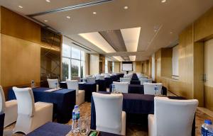 a room with blue tables and white chairs at DoubleTree by Hilton Hotel Xiamen - Wuyuan Bay in Xiamen