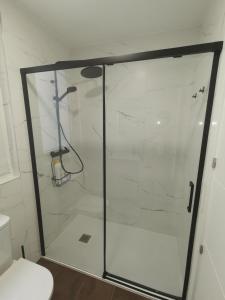 y baño con ducha y puerta de cristal. en Casa Elisa 2 en León