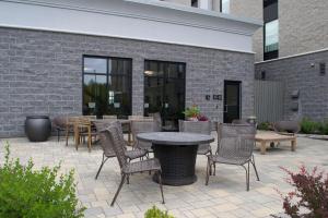 eine Terrasse mit einem Tisch, Stühlen und einer Ziegelwand in der Unterkunft Chateau Fredericton, Trademark Collection by Wyndham in Fredericton