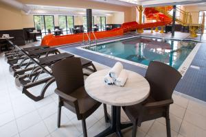 um restaurante com mesa e cadeiras e uma piscina em Chateau Fredericton, Trademark Collection by Wyndham em Fredericton