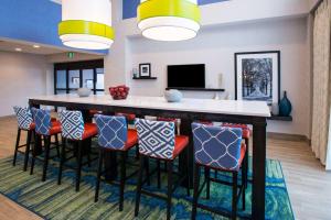 a large kitchen with a bar with stools at Chateau Fredericton, Trademark Collection by Wyndham in Fredericton