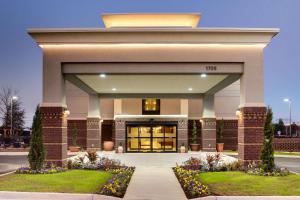 a large building with a front entrance with flowers at Hampton Inn & Suites Cordele in Cordele
