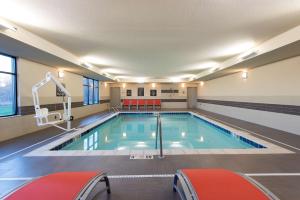 una piscina en un gimnasio con sillas rojas en Homewood Suites by Hilton Cleveland/Sheffield, en Avon