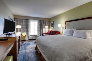 a hotel room with a bed and a flat screen tv at Hampton Inn & Suites Cordele in Cordele