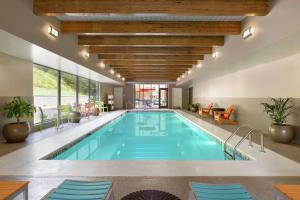 una piscina en un hotel con sillas azules y una habitación grande en Home2 Suites by Hilton Cartersville, en Cartersville