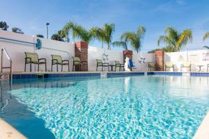 a large swimming pool with chairs and a building at Hampton Inn - Palatka in Palatka