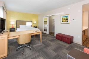 a hotel room with a bed and a desk with a computer at Hampton Inn - Palatka in Palatka