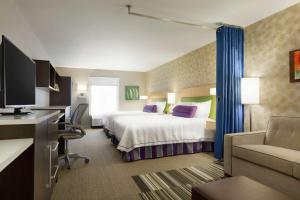 une chambre d'hôtel avec un lit et un canapé dans l'établissement Home2 Suites By Hilton Macon I-75 North, à Macon