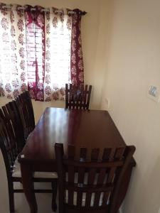 a dining room table and chairs in front of a window at Bangalore homestay in Bangalore