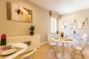 una sala da pranzo con tavolo e sedie bianche di Casa Ilaria a Napoli